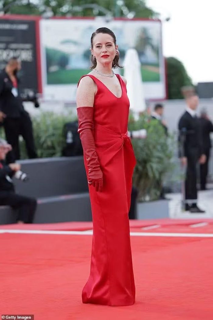 Nữ diễn viên Claire Foy nổi bật trong chiếc váy không tay màu đỏ Bottega Veneta, phối cùng giày cao gót Christian Louboutin và găng tay opera. Trong phim, cô đảm nhận vai Jules Davies, biên tập viên mảng Phụ nữ đầu tiên của tờ The Sun. Ảnh: Shutterstock/Getty Images.