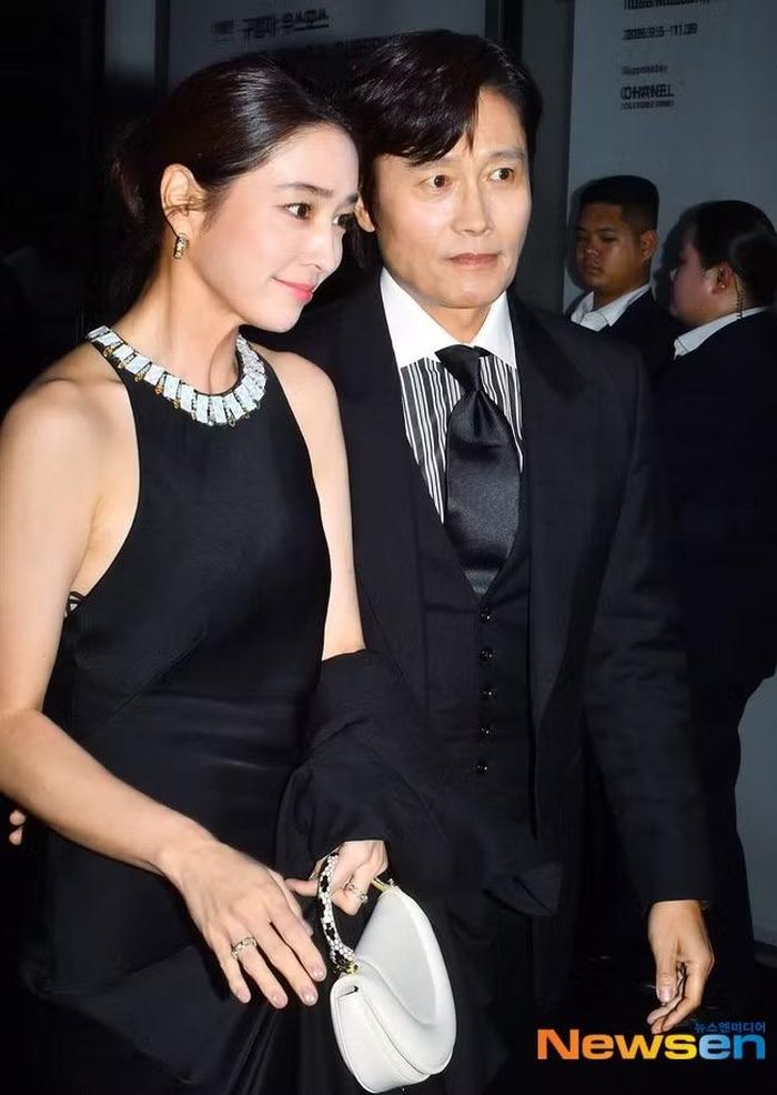 Vợ chồng Lee Byung Hun và Lee Min Jung gây chú ý với những cử chỉ tình tứ, quan tâm lẫn nhau. Nữ diễn viên xuất hiện với bộ váy đen thanh lịch, được chồng dìu xuống xe. Họ kết hôn từ năm 2013, đến nay đã có một trai, một gái. Lee Byung Hun từng vướng scandal ngoại tình với hai cô gái trẻ năm 2014 khi vợ anh đang mang thai. Nhưng nhờ tài năng diễn xuất Lee Byung Hun vẫn là ngôi sao điện ảnh được săn đón bậc nhất tại Hàn Quốc. Về phía Lee Min Jung, cô thỉnh thoảng mới tham gia diễn xuất, chủ yếu dành thời gian để chăm sóc gia đình. Năm 2025, Lee Min Jung trở lại với bộ phim Villains (Cuộc chơi của kẻ ác).