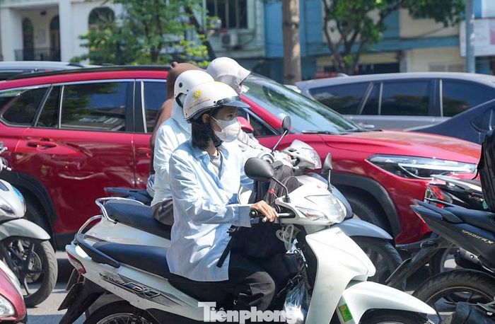 Nhiều người đi xe máy phải di chuyển từng mét giữa dòng phương tiện ken đặc. Có người mất hơn một giờ vẫn chưa qua được khu vực cầu Vĩnh Tuy.