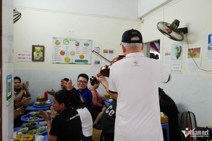 Quán ốc nhỏ ở phường Đống Đa càng thêm đông khách vì màn biểu diễn violin thú vị của ông Sỹ. Ảnh: Linh Trang
