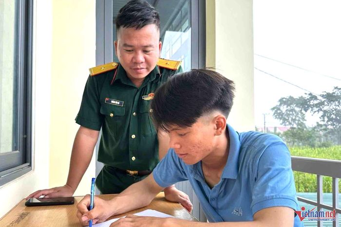  Thiếu tá Hoàng Văn Hà hướng dẫn công dân làm thủ tục đăng ký tình nguyện nhập ngũ. Ảnh: Trung Hải