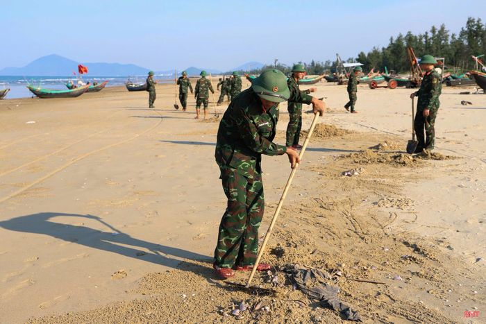 Chiến sỹ Trung đoàn 841 - Bộ CHQS Hà Tĩnh và người dân tiến hành xử lý vỏ ngao tím để đảm bảo vệ sinh môi trường