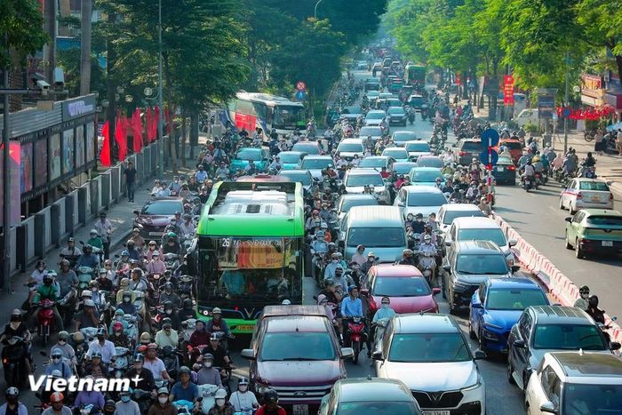 Xe máy len lỏi vào khe hẹp giữa các ôtô trên đường Thái Hà.