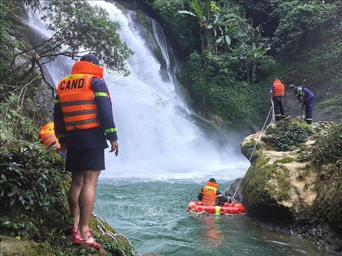 Lực lượng cứu nạn sử dụng xuồng chuyên dụng tiếp cận khu vực hang dưới chân thác. Ảnh: TTXVN phát