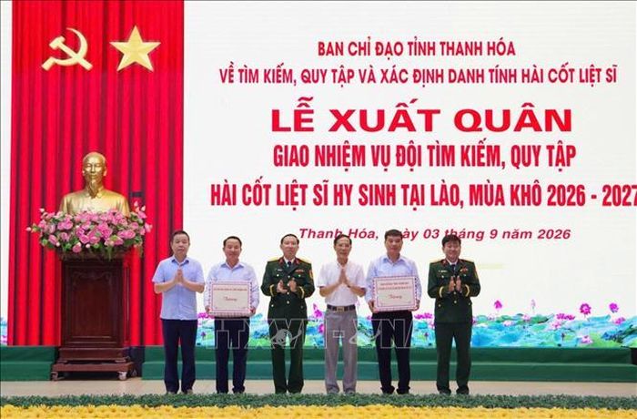 Phó Chủ tịch UBND tỉnh Đầu Thanh Tùng và các đồng chí trong Ban Chỉ đạo tỉnh tặng quà cho đội quy tập. Ảnh: TTXVN phát