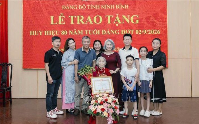 Các con, cháu chụp ảnh lưu niệm cùng đảng viên lão thành Nguyễn Thị Chủy, Chi bộ thôn 2 Mạc Hạ, Đảng bộ xã Nam Xang trong ngày nhận Huy hiệu 80 năm tuổi Đảng.