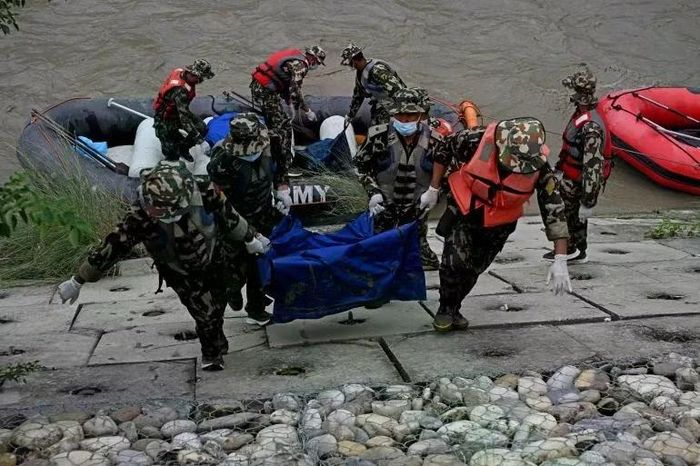 Các binh sĩ quân đội Nepal khiêng thi thể các nạn nhân lũ lụt trong một chiến dịch tìm kiếm dọc sông Narayani tại Bharatpur thuộc quận Chitwan của Nepal vào ngày 31/8. Ảnh: aFP.