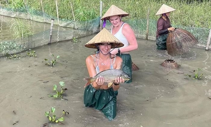 Du khách trải nghiệm bắt cá cùng người dân địa phương. Những công việc vốn gắn với sinh kế nay trở thành một phần trong hành trình khám phá nông thôn