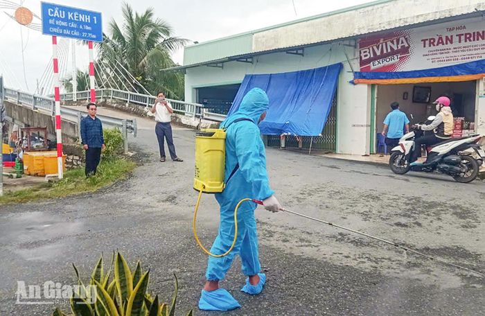 Lực lượng chức năng xã Vĩnh Thuận phun xịt khử trùng, tiêu độc môi trường phòng ngừa dịch bệnh trên địa bàn. Ảnh: MINH LÊ