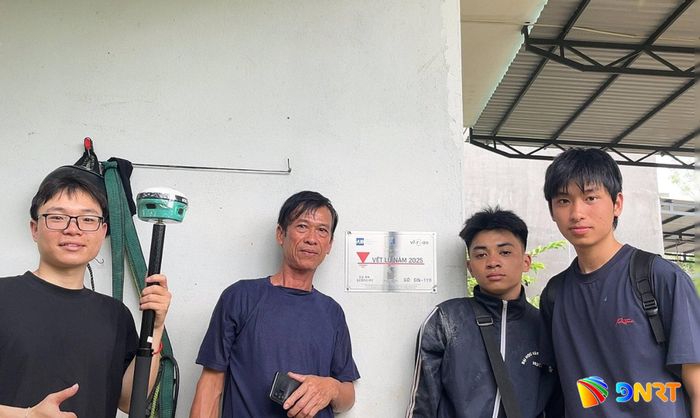 Nhóm nghiên cứu của Trường Đại học Xây dựng Hà Nội và người dân phường Điện Bàn gắn biển vết lũ năm 2025. Ảnh: ĐVCC