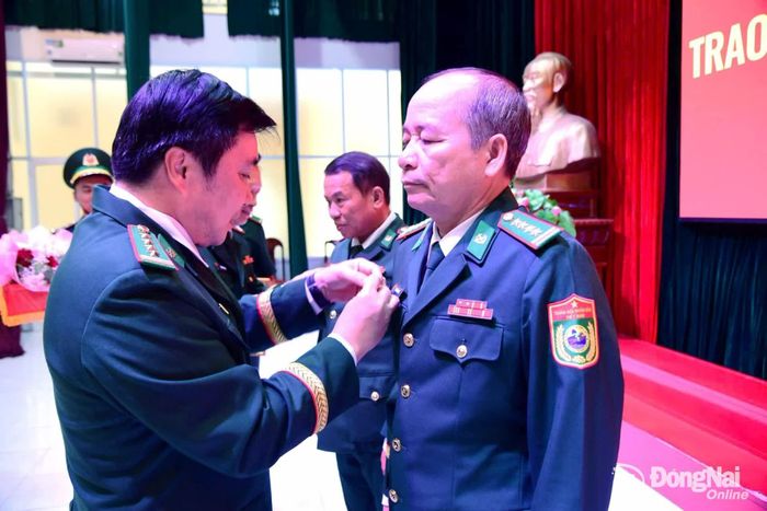 Đại tá Nguyễn Anh Đức, Phó Bí thư Đảng ủy, Chỉ huy trưởng Bộ đội Biên phòng thành phố Đồng Nai gắn Huy hiệu 35 năm tuổi Đảng cho Đại tá Bùi Minh Soái. Ảnh: Thịnh Kiệt