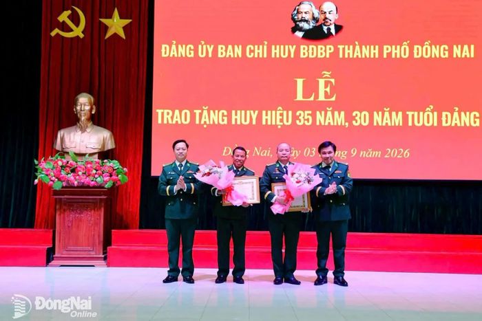 Thủ trưởng Đảng ủy Bộ đội Biên phòng thành phố Đồng Nai trao Huy hiệu 35 năm tuổi Đảng cho Đại tá Hoàng Văn Thành (thứ 2 từ trái qua) và Đại tá Bùi Minh Soái. Ảnh: Thịnh Kiệt