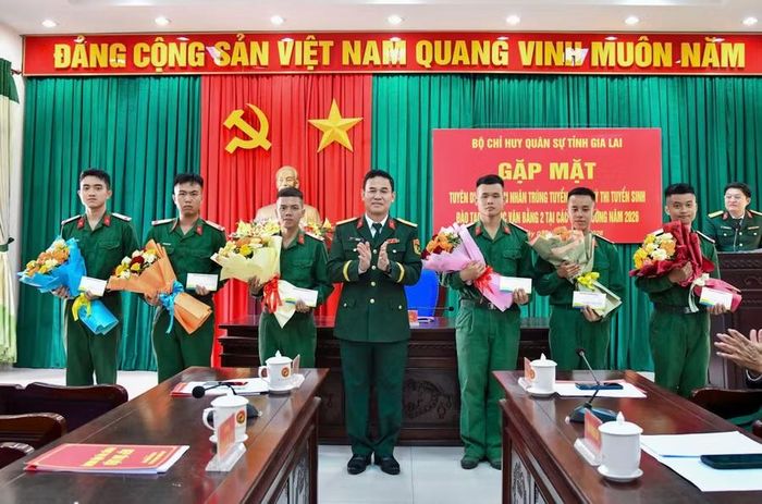 Đại tá Võ Tấn Tài - Chính ủy Bộ CHQS tỉnh Gia Lai tặng hoa và quà chúc mừng các quân nhân trúng tuyển đại học. Ảnh: Anh Tuấn