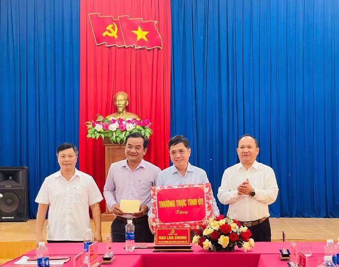  Đồng chí Rah Lan Chung (ngoài cùng, bên phải) tặng quà của Thường trực Tỉnh ủy cho Ban Thường vụ Đảng ủy xã Ia Phí. Ảnh: P.D 