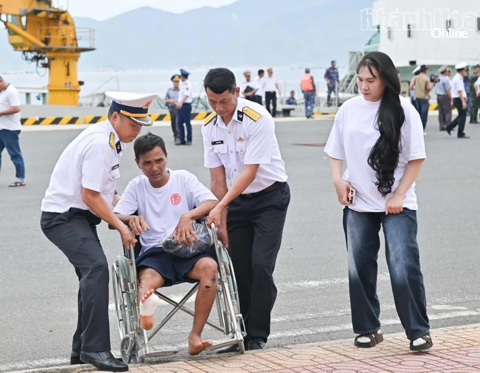 Cán bộ Vùng 4 Hải quân hỗ trợ ngư dân Đỗ Văn Tự di chuyển vào nơi tiếp đón.