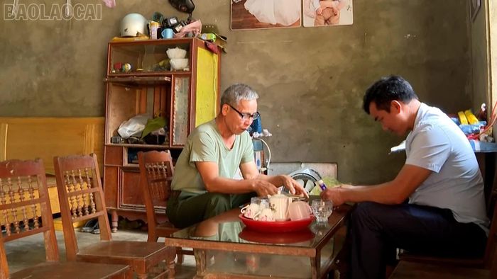 Ông Lục Bỉnh Khiêm (trái) và những tấm huy hiệu Bác Hồ của gia đình.