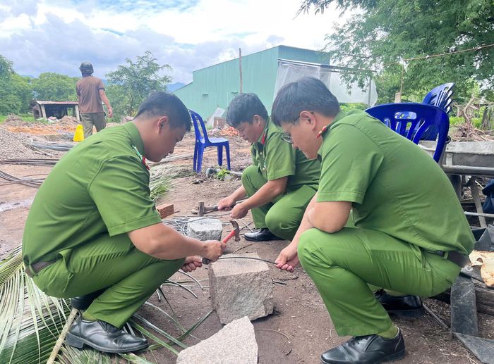 Cán bộ, chiến sĩ Công an xã Hàm Thuận Bắc hỗ trợ cắt thép làm nhà cho gia đình ông Dũng