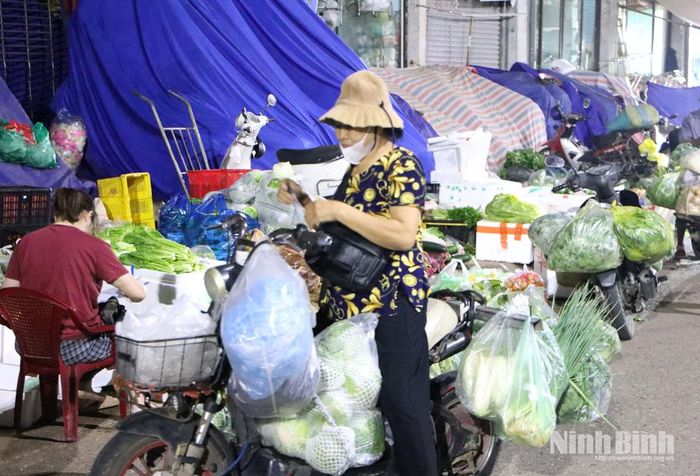 Chiếc xe máy chất đầy hàng hóa được tiểu thương mua từ chợ đêm, chuẩn bị vận chuyển về điểm bán.