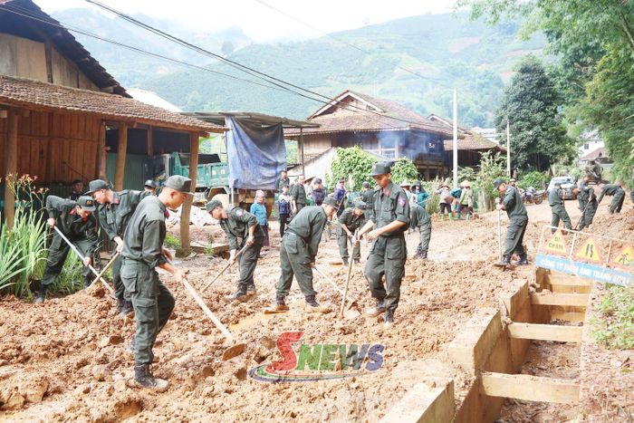 Cán bộ, chiến sĩ Tiểu đoàn 2 tham gia giúp nhân dân bản Chiềng Dong, xã Chiềng Mai khắc phục đường giao thông bị sạt lở do mưa lớn.