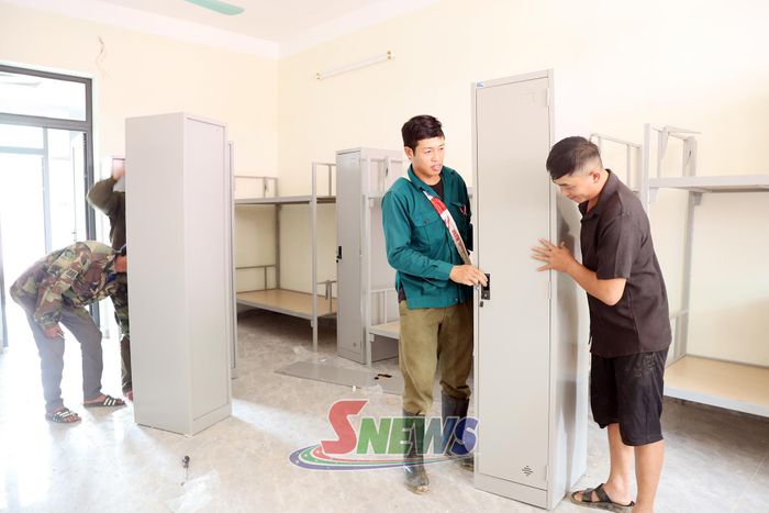 Phụ huynh học sinh hỗ trợ lắp đặt cơ sở vật chất khu bán trú học sinh.