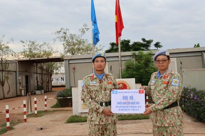 Đại diện chỉ huy Bệnh viện Dã chiến cấp 2 số 7 trao biểu trưng số tiền 10 triệu đồng ủng hộ Chiến dịch “500 ngày đêm đẩy mạnh thực hiện tìm kiếm, quy tập và xác định danh tính hài cốt liệt sĩ”.