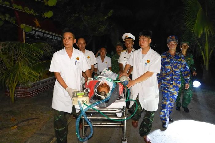 Các y bác sĩ vận chuyển người bệnh từ Bệnh xá Đảo Trường Sa lớn ra bãi đáp trực thăng.