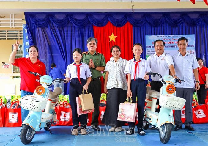 Hai học sinh Trường THCS Trần Huỳnh có hoàn cảnh đặc biệt khó khăn được trao tặng xe đạp điện.