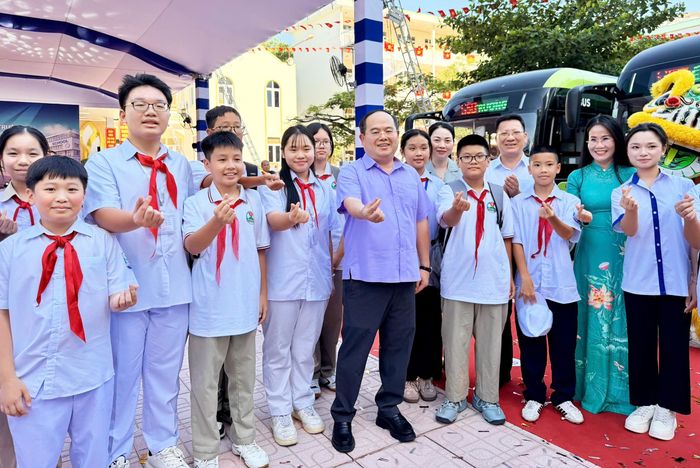 Bí thư Thành ủy Quảng Ninh Quản Minh Cường chụp hình cùng các học sinh sau khi trải nghiệm thực tế xe buýt điện trong ngày khai trương. (Ảnh: Thanh Tùng)