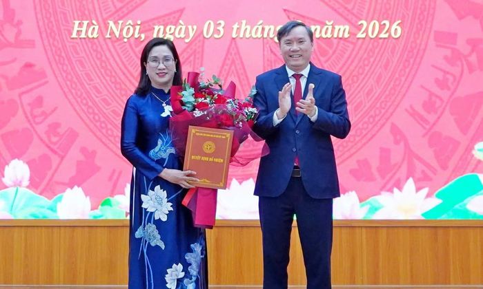 Chủ tịch Viện Hàn lâm Khoa học xã hội Việt Nam Lê Văn Lợi trao quyết định, tặng hoa bà Đinh Thị Mai.