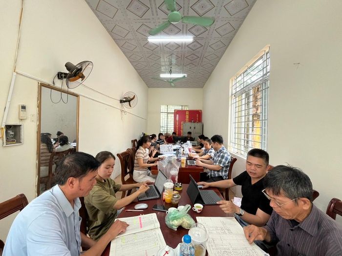 Bí thư chi bộ và các trưởng thôn tích cực tham gia rà soát danh sách, hồ sơ từng hộ dân. Ảnh: Nhân Công