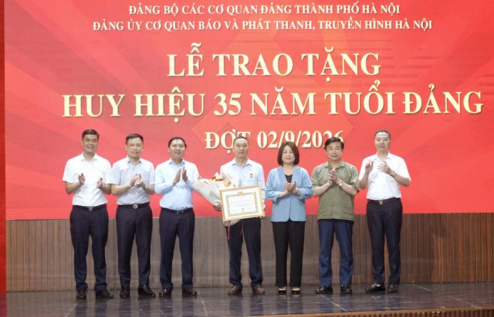 Phó Bí thư Đảng ủy các cơ quan Đảng thành phố Hà Nội Phạm Thị Nguyên Hạnh và Thành ủy viên, Bí thư Đảng ủy, Giám đốc Cơ quan Báo và Phát thanh, Truyền hình Hà Nội Nguyễn Thanh Liêm cùng các đồng chí trong Đảng ủy cơ quan tặng hoa chúc mừng đảng viên Nguyễn Thanh Luận. Ảnh: Phạm Hùng