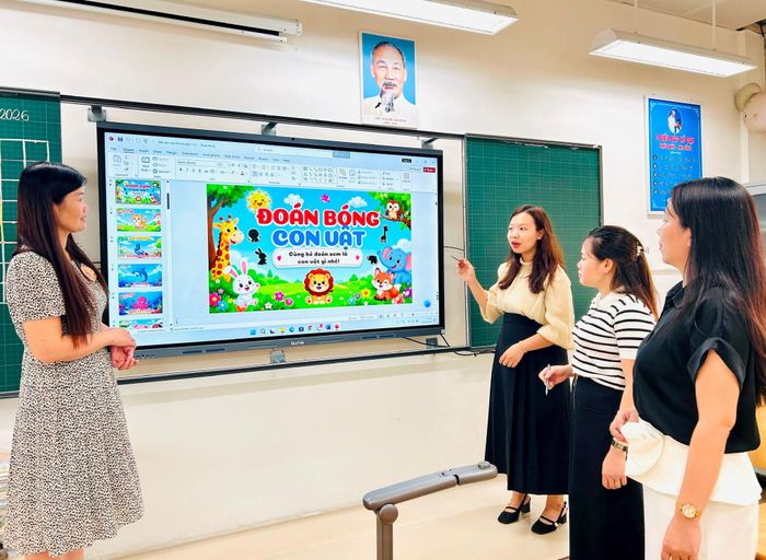 Hiệu trưởng Trường Tiểu học Tam Trinh Trần Thị Tuyết Hường (bên trái) trao đổi với giáo viên sử dụng các thiết bị phục vụ dạy học. Ảnh: Trần Oanh