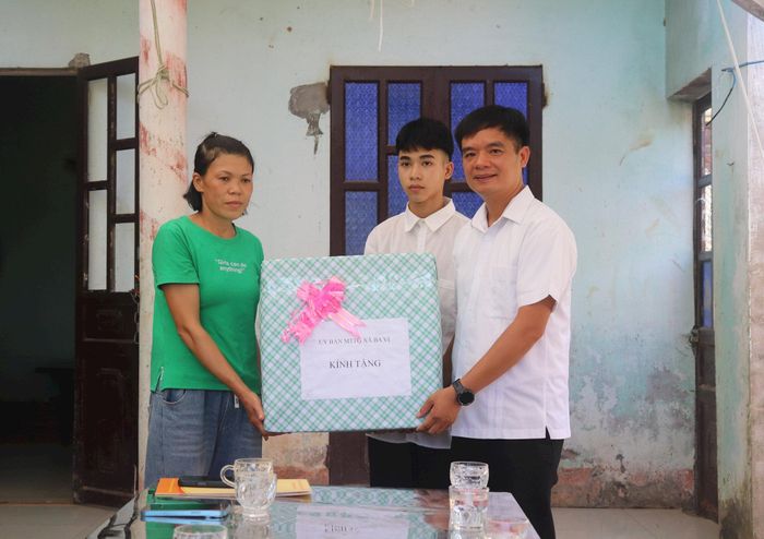 Chủ tịch Ủy ban MTTQ Việt Nam xã Ba Vì Đỗ Văn Minh trao quà hỗ trợ cho gia đình em Mai Dương Anh Thắng. Ảnh: Hiền Chi