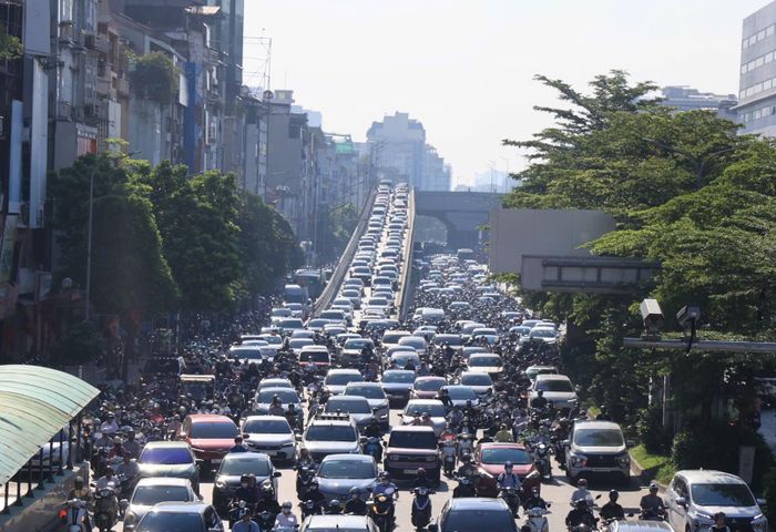 Càng về gần cầu vượt Ngã Tư Sở, mật độ phương tiện càng cao. Có thời điểm, khoảng 6 hàng ô tô nối tiếp nhau, di chuyển chậm qua khu vực. (Lối xuống đường Vành đai 2 giao với Ngã Tư Sở)