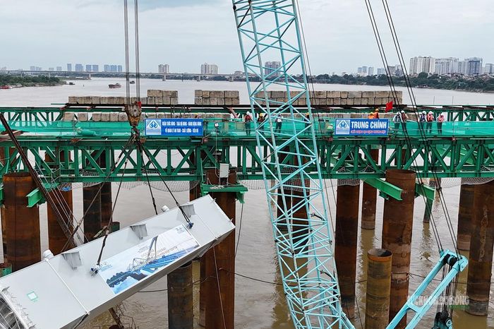 Một đốt dầm dọc chủ được cẩu lên vị trí lắp dựng tại nhịp TC3-TC4. Ảnh: T.Anh