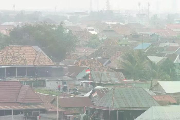 Những ngôi nhà bị bao phủ khói mù từ các vụ cháy rừng bao phủ thành phố Palembang, Nam Sumatra, Indonesia