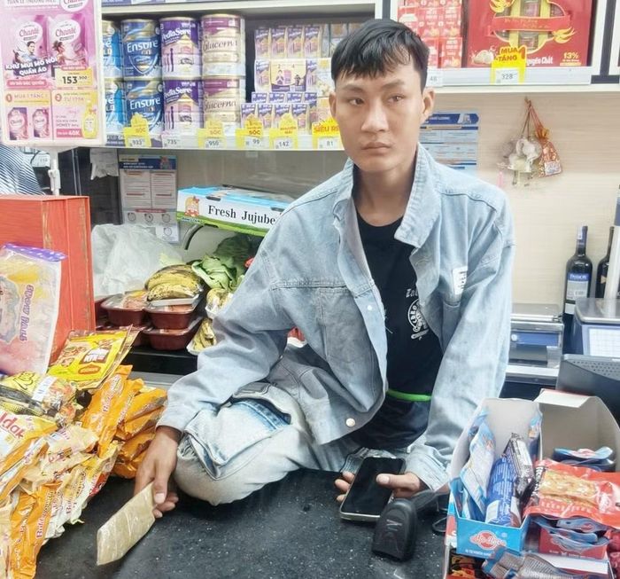 Thấy nhân viên thu ngân không làm theo, Tiến đã treo vào bên trong quầy, cướp điện thoại và trèo ngược ra ngoài