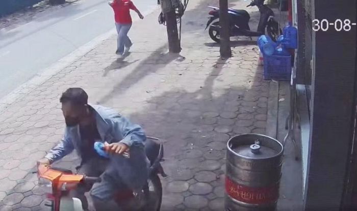 Tiến lên xe máy tháo chạy khỏi hiện trường, phía sau là bị hại (áo đỏ) đuổi theo (hình ảnh trích xuất từ camera an ninh)