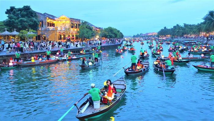 Du khách chèo ghe trên sông Hoài ngắm phố cổ Hội An. Ảnh: Tấn Thành.