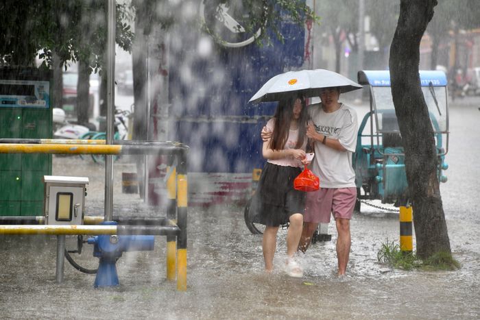  Người dân đi bộ dọc theo một con phố ngập nước giữa cơn mưa lớn ở Phúc Châu, tỉnh Phúc Kiến, Trung Quốc, ngày 3/9, sau khi bão Saudel đổ bộ lần thứ ba. Ảnh: Reuters. 