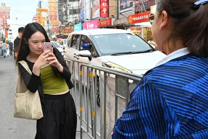  Thanaporn Charoenchuea chụp ảnh cho khách hàng của mình tại Bangkok, Thái Lan. Ảnh: Kyodo News. 