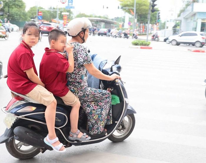 Nhiều phụ huynh vẫn quên đội mũ bảo hiểm cho con, chở 3 người trên một xe