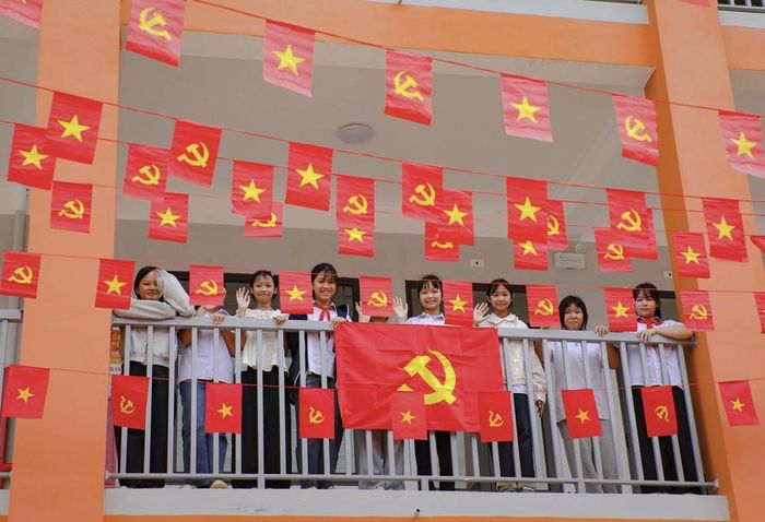 Học sinh Trường Phổ thông nội trú Tiểu học và THCS Sam Mứn tươi vui bên những lá cờ Đảng, cờ Tổ quốc được trang trí trên hành lang. Ảnh: Xuân Tư - TTXVN