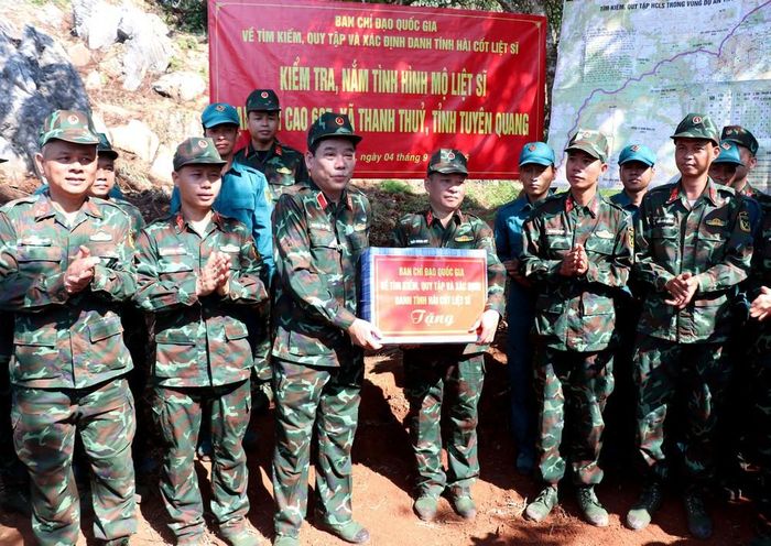 Thượng tướng Nguyễn Văn Gấu, Thứ trưởng Bộ Quốc phòng trao tặng quà, động viên, chia sẻ với đội tìm kiếm hài cốt liệt sĩ tại điểm cao 685 thuộc xã Thanh Thủy, tỉnh Tuyên Quang. Ảnh: Đức Thọ - TTXVN
