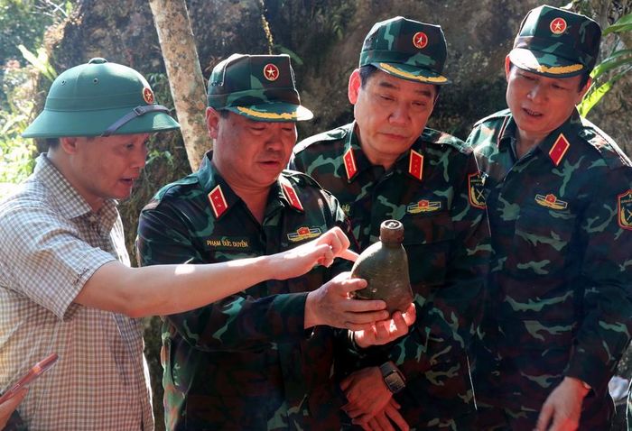 Thượng tướng Nguyễn Văn Gấu, Thứ trưởng Bộ Quốc phòng tỉ mỉ xem những vật dụng còn sót lại tại điểm cao 685. Ảnh: Đức Thọ - TTXVN
