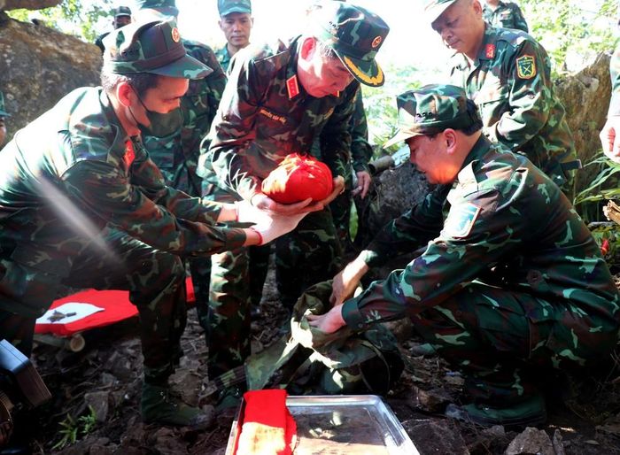 Thượng tướng Nguyễn Văn Gấu, Thứ trưởng Bộ Quốc phòng cùng lực lượng nhẹ nhàng đưa hài cốt liệt sĩ vừa được tìm thấy về điểm quy tập. Ảnh: Đức Thọ - TTXVN