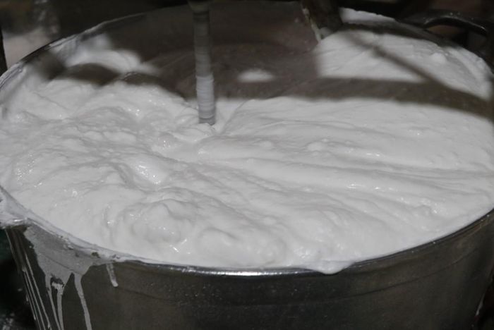 Gạo tẻ sau khi quấy trên bếp tiếp tục được trộn đều cho mịn. Ảnh: Thanh Thương - TTXVN