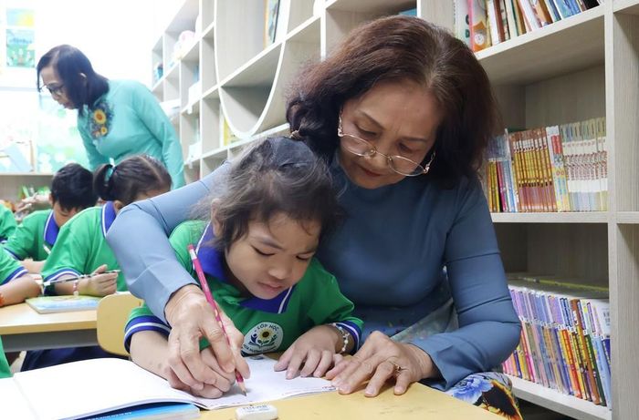 Bệnh nhi ung thư tập viết với sự hướng dẫn của giáo viên tình nguyện tại Lớp học Hoa hướng dương, Bệnh viện Ung bướu Thành phố Hồ Chí Minh. Ảnh: Đinh Hằng - TTXVN