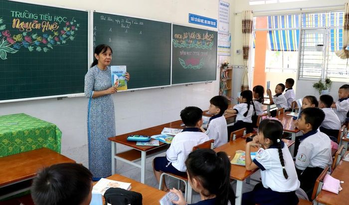Giáo viên Trường Tiểu học Nguyễn Huệ, phường Long Châu, Vĩnh Long hướng dẫn học sinh chuẩn bị cho năm học mới. Ảnh: Lê Thúy Hằng – TTXVN