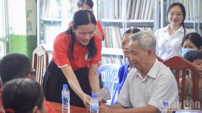 Cô Nguyễn Thị Minh Tâm trao quà cho những hoàn cảnh khó khăn. (Ảnh: LÝ OANH)